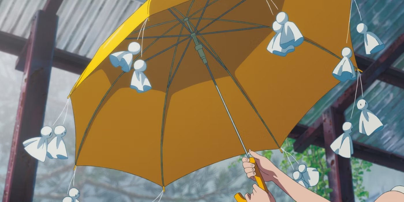 an umbrella from Weathering With You has teru teru bouzu hanging from each spoke of the umbrella.